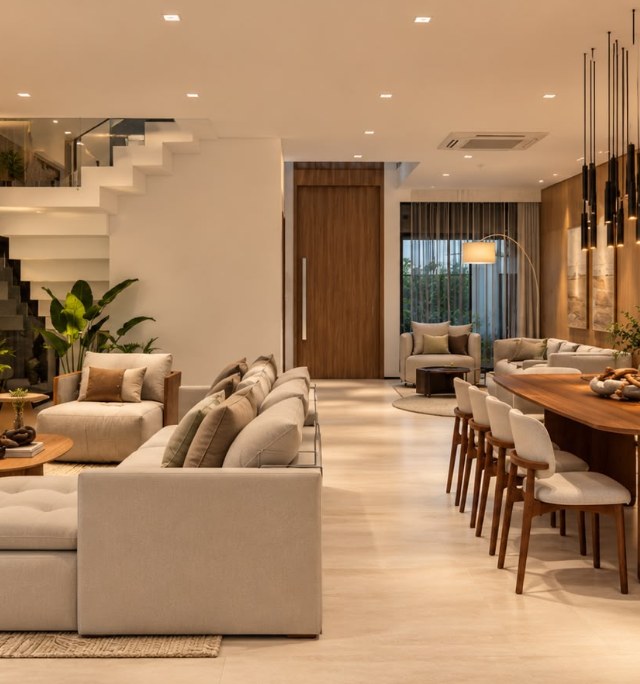 Sala de estar e jantar integradas com marcenaria em madeira e iluminação quente